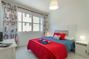 a bedroom with a bed with a red blanket at Casa Cabana in El Médano