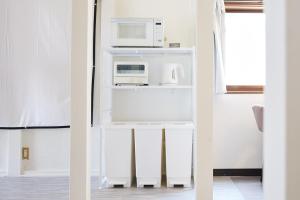 a kitchen with two microwaves and a microwave at Knot Kyonan in Katsuyama