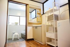 a bathroom with a sink and a toilet and a glass door at Knot Kyonan in Katsuyama