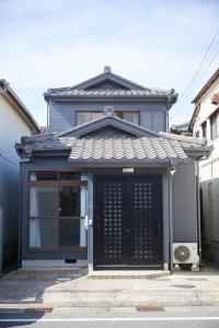 a house with a black door in a street at Knot Kyonan in Katsuyama