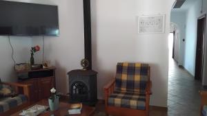 a living room with a fireplace and a chair at CCCA Monte Loureiro in Raposeira