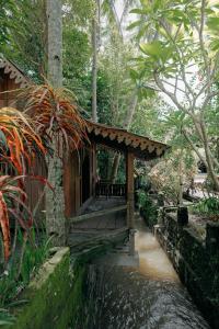 a small building with a porch next to a river at Sikepan Villa Borobudur in Mendut