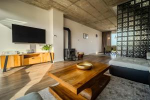 a living room with a tv and a wooden table at LomniSki apartment in Veľká Lomnica