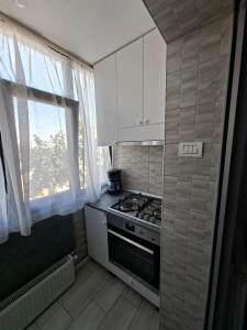 a small kitchen with a stove and a window at Exclusiv new family in Năvodari