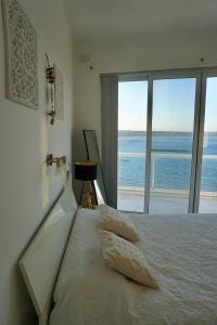 a bedroom with a bed with a view of the ocean at Very nice place by the sea in Is-Sellum