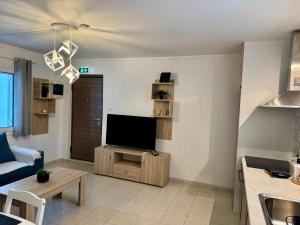 a living room with a flat screen tv on a stand at Lemon Tree Residence in Artemida
