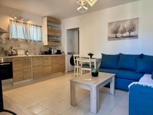 a living room with a blue couch and a table at Lemon Tree Residence in Artemida