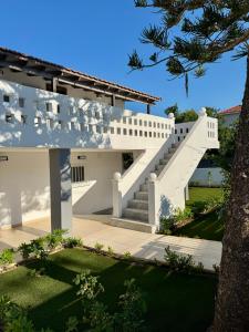 a white house with stairs and a tree at Lemon Tree Residence in Artemida