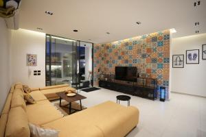 a living room with a couch and a tv at Blooms Villa in Al Rama