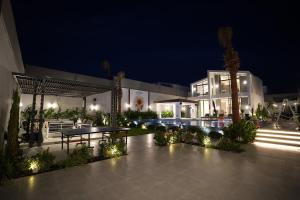 a night view of a building with a table and benches at Blooms Villa in Al Rama