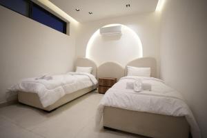 a bedroom with two beds and a window at Blooms Villa in Al Rama +16 photos