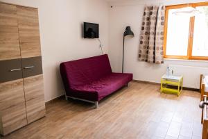 a living room with a red couch and a window at Kentaur Guesthouse in Atea