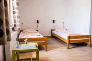 two beds in a room with a table and a chair at Kentaur Guesthouse in Atea
