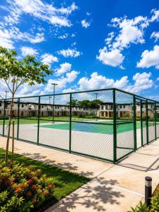 a tennis court with a green fence at Idesia Lipa Custodio Suites in Lipa