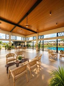 a large lobby with tables and chairs and windows at Idesia Lipa Custodio Suites in Lipa