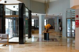 a lobby with a vase of flowers on a table at Marbel Hotel by PalmWings in Kuşadası +70 photos