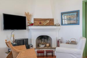 a living room with a fireplace and a flat screen tv at Tinos Sunset House in Tinos