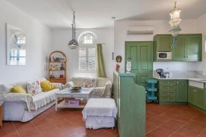 a kitchen with green cabinets and a living room at Tinos Sunset House in Tinos