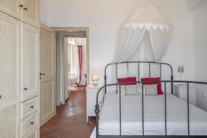 a bedroom with a canopy bed with red pillows at Tinos Sunset House in Tinos