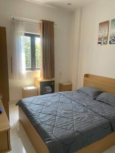 a bedroom with a blue bed and a window at Lya Homestay CMT8 Da Nang in Danang