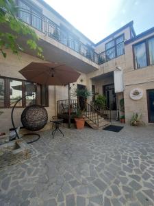 a patio with an umbrella in front of a building at Urban Nest old Tbilisi hotel in Tbilisi City