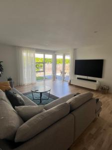 a living room with a couch and a flat screen tv at Spacious Luxury Villa in Copenhagen in Copenhagen