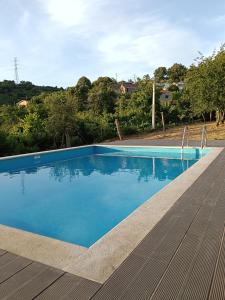 a blue swimming pool on a wooden deck at Casa dos Leme in Baião