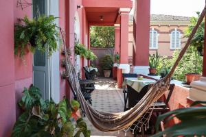 a hammock on a balcony with a table and chairs at Guesthouse Villa Dourada in Rio de Janeiro