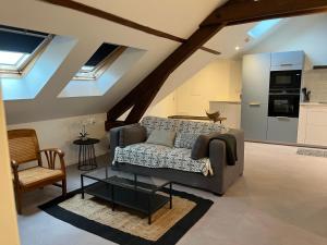 a living room with a couch and a kitchen at Le Miel des Muses in Brive-la-Gaillarde