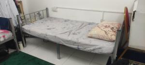 a small bed in a room with a pillow on it at Living room in Muscat