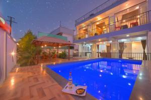 a swimming pool in front of a house at night at I EMPYREAN STAYS ll MYSTICAL STONE VILLA ll 4BHK II AC II PRIVATE POOL II in Lonavala