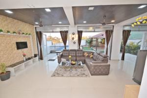 a living room with a couch and a tv at I EMPYREAN STAYS ll MYSTICAL STONE VILLA ll 4BHK II AC II PRIVATE POOL II in Lonavala