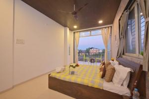 a bedroom with a bed with a large window at I EMPYREAN STAYS ll MYSTICAL STONE VILLA ll 4BHK II AC II PRIVATE POOL II in Lonavala