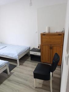 a bedroom with two beds and a chair and a dresser at air&wizz II in Dubrave Gornje