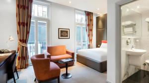 a hotel room with a bed and a chair at Guild Hotel Marble Arch in London +61 photos