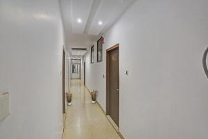 a hallway with white walls and a wooden door at Hotel O Dps Inn in Allahābād