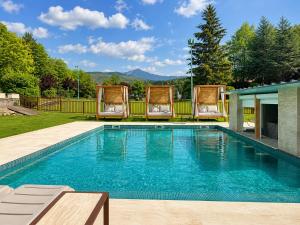 a swimming pool with two chairs and a poolvisorvisor at ELS OCELLS Apartaments i Cases Rurals in Camprodon