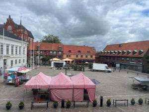 a red and white tent in a courtyard with buildings at One room apartment the Square in Ystad