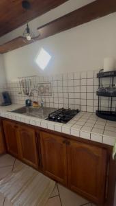 a kitchen counter with a sink and a stove at Une Parenthèse à 2 in Saint-Joseph