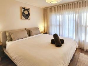 a bedroom with a large white bed and a window at Red Gum & Stone - Peace Space Nature in Warburton