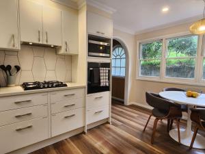 a kitchen with white cabinets and a table at Red Gum & Stone - Peace Space Nature in Warburton +33 photos