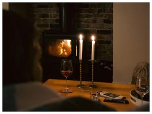 a table with two glasses of wine and two candles at Red Gum & Stone - Peace Space Nature in Warburton