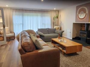 a living room with a couch and a coffee table at Red Gum & Stone - Peace Space Nature in Warburton