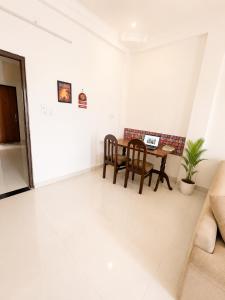 a living room with a table with a laptop on it at Kesarionstay in Indore