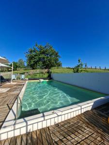 a swimming pool on a deck with a blue sky at Chambres d'hotes aux Petits Belézins in Saint-Amour