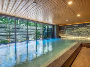 an indoor swimming pool with a large window at KAMENOI HOTEL Fuji in Fujiyoshida