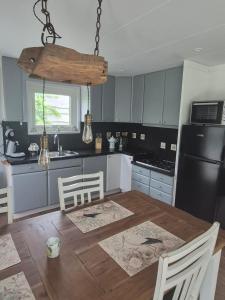 a kitchen with a wooden table and a black refrigerator at Het ooievaarsnest in Warmond +13 photos