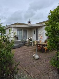 a small house with a patio and a table at Het ooievaarsnest in Warmond