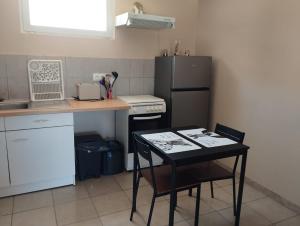 a small kitchen with a table and a refrigerator at Studio La Gière in Beaumes-de-Venise