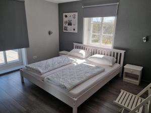 a bedroom with a bed with white sheets and pillows at Eifel-Dream Schneifelhaus in Kobscheid +23 photos